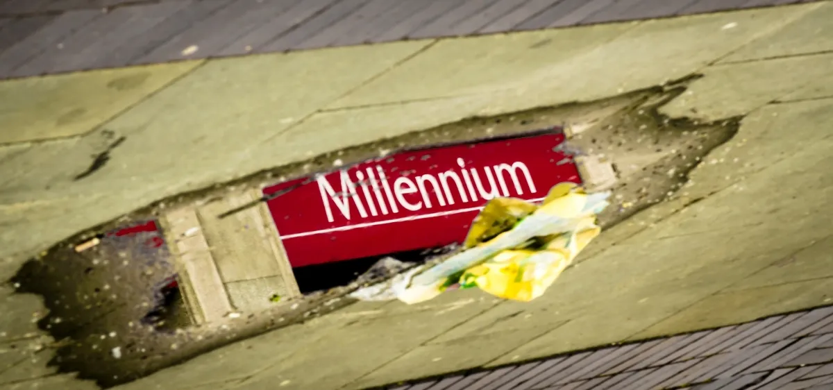 Red Millennium sign reflected in a shallow puddle